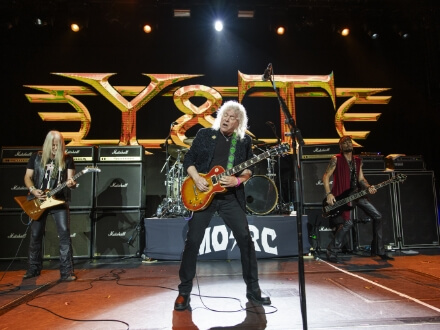 5 | Monsters Of Rock Cruise Hard rock band performs on a lit stage with a guitarist center stage, drummer in back, and large 'Y&T' logo backdrop behind them, amps on both sides