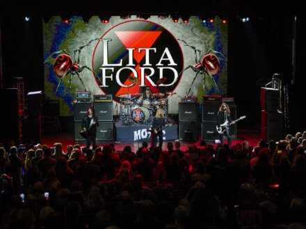 6 | Monsters Of Rock Cruise Live rock concert on stage with a large screen reading 'LITA FORD' and a crowd watching in the foreground.
